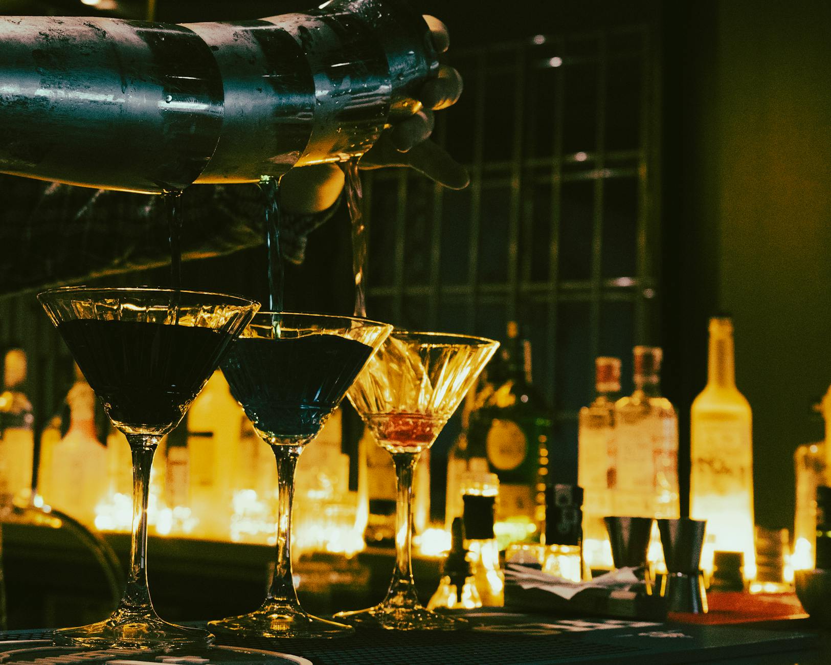 Stylish bar interior in Lisbon with low lighting and bartender mixing cocktails
