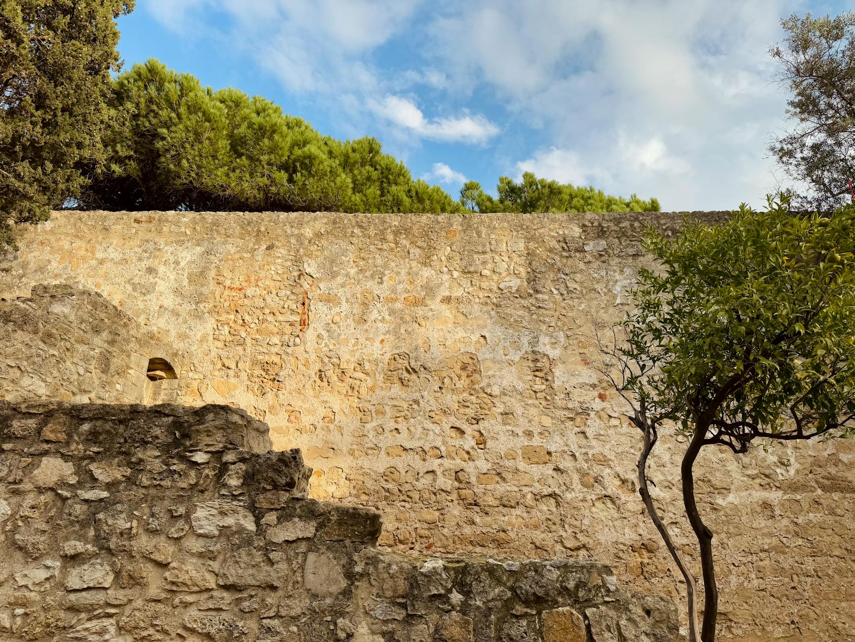 Historic walls of São Jorge Castle overlooking the rooftops of Alfama in Lisbon