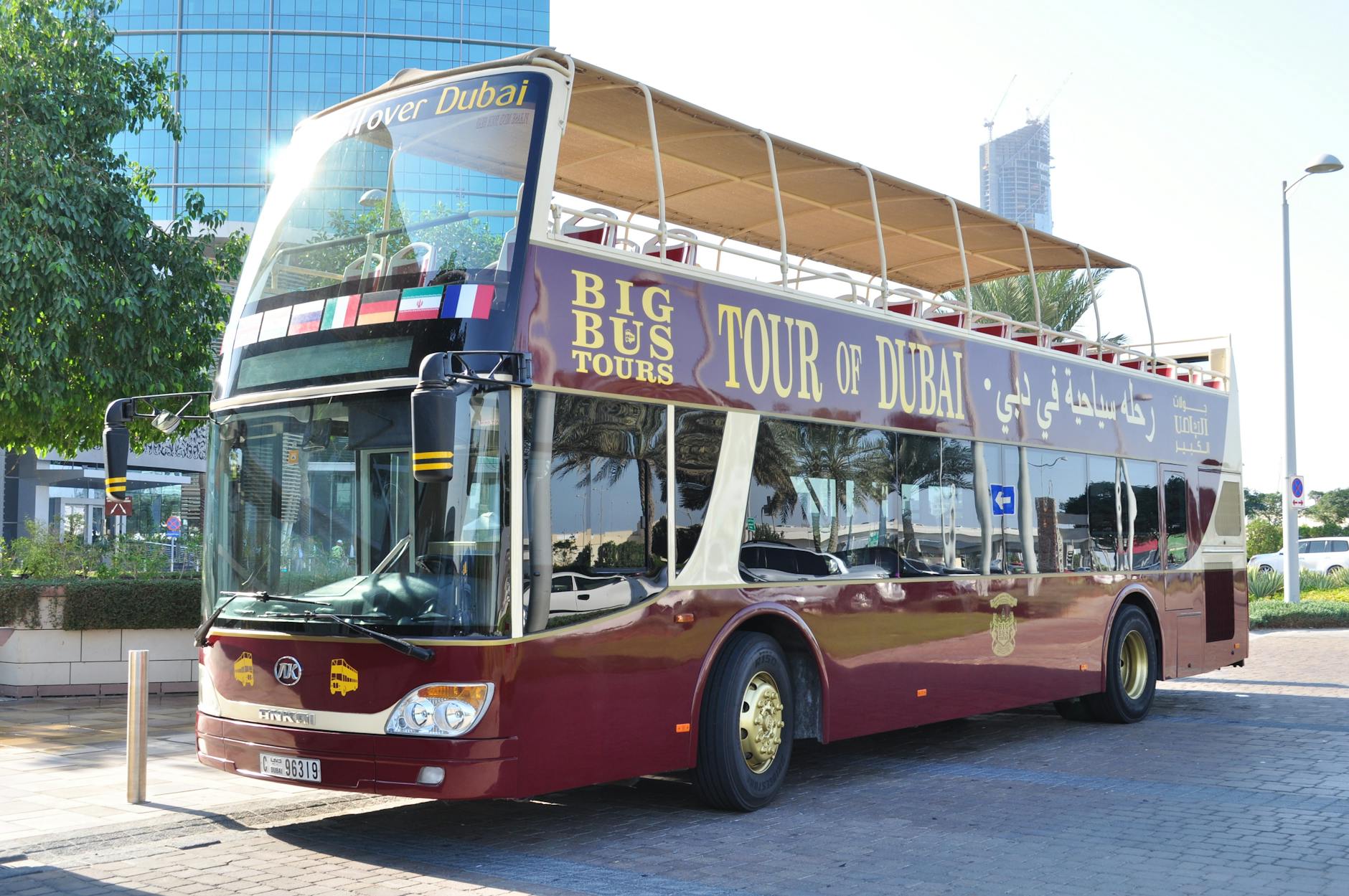 Yellow open-top hop-on hop-off tour bus on a Lisbon street near Praça do Comércio