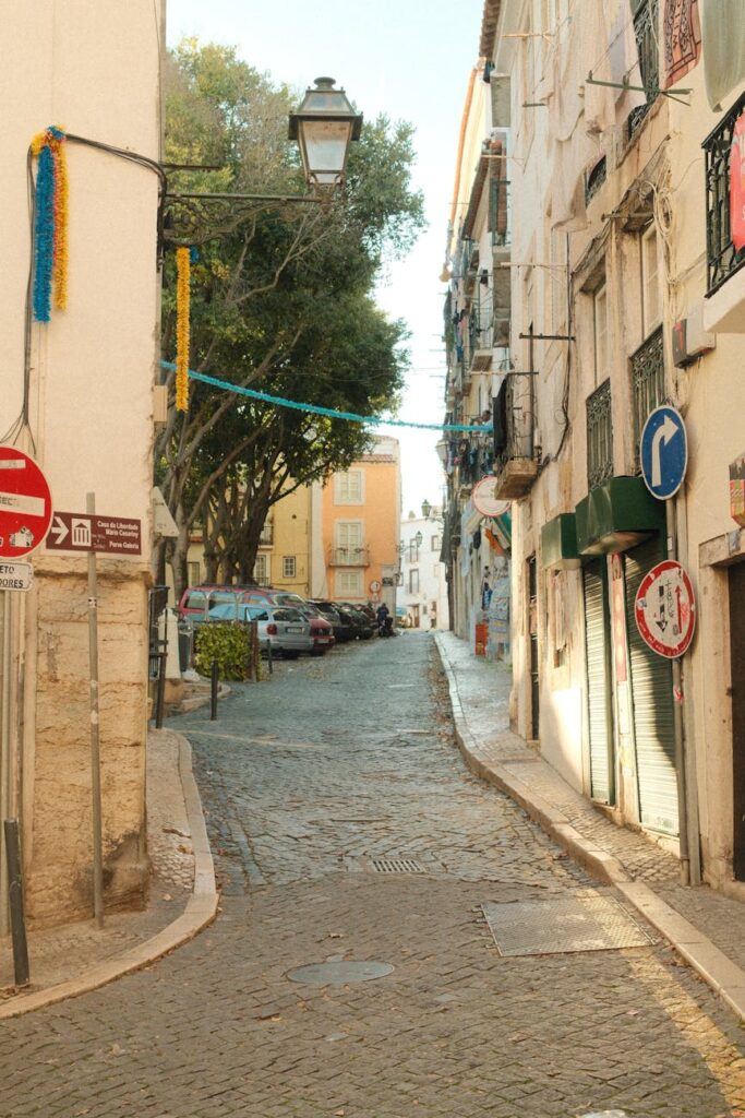 Charming cobblestone lane in Lisbon's historic Alfama neighborhood with festive decorations