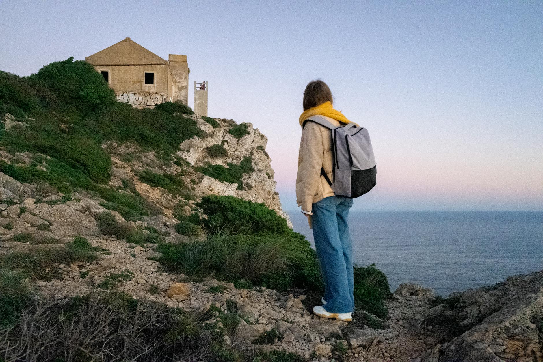 First-time visitor with backpack overlooking Lisbon's red rooftops from a hilltop viewpoint
