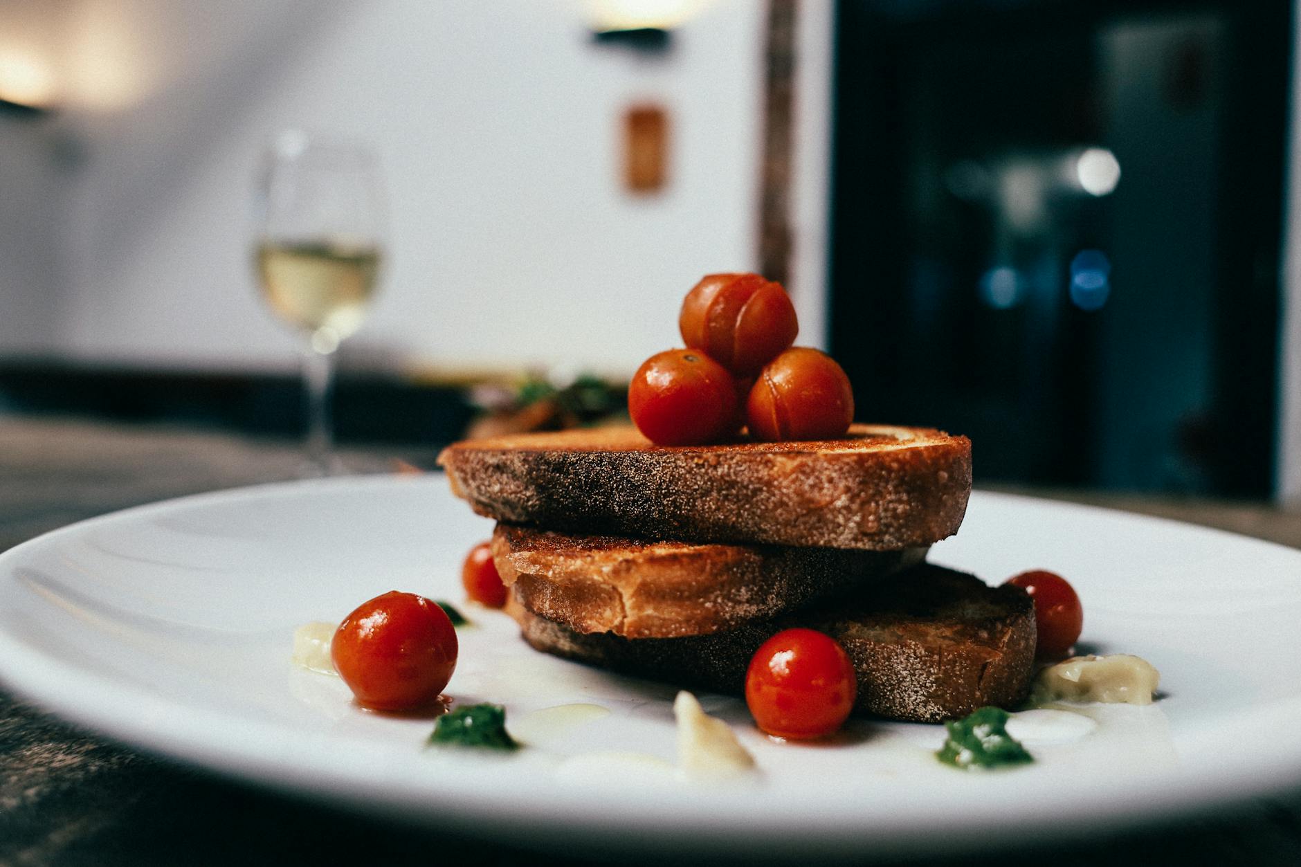 Plate of Portuguese petiscos and wine glasses on a tasca table in Lisbon