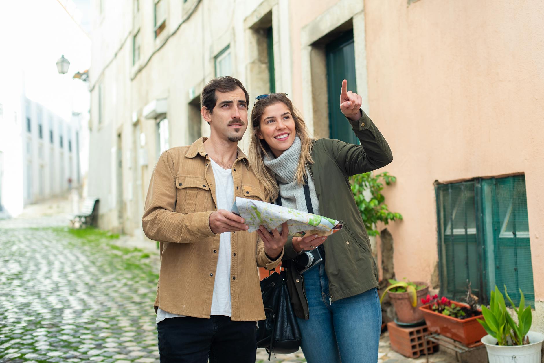 Tourist consulting a Lisbon map on a cobblestone street with traditional yellow buildings