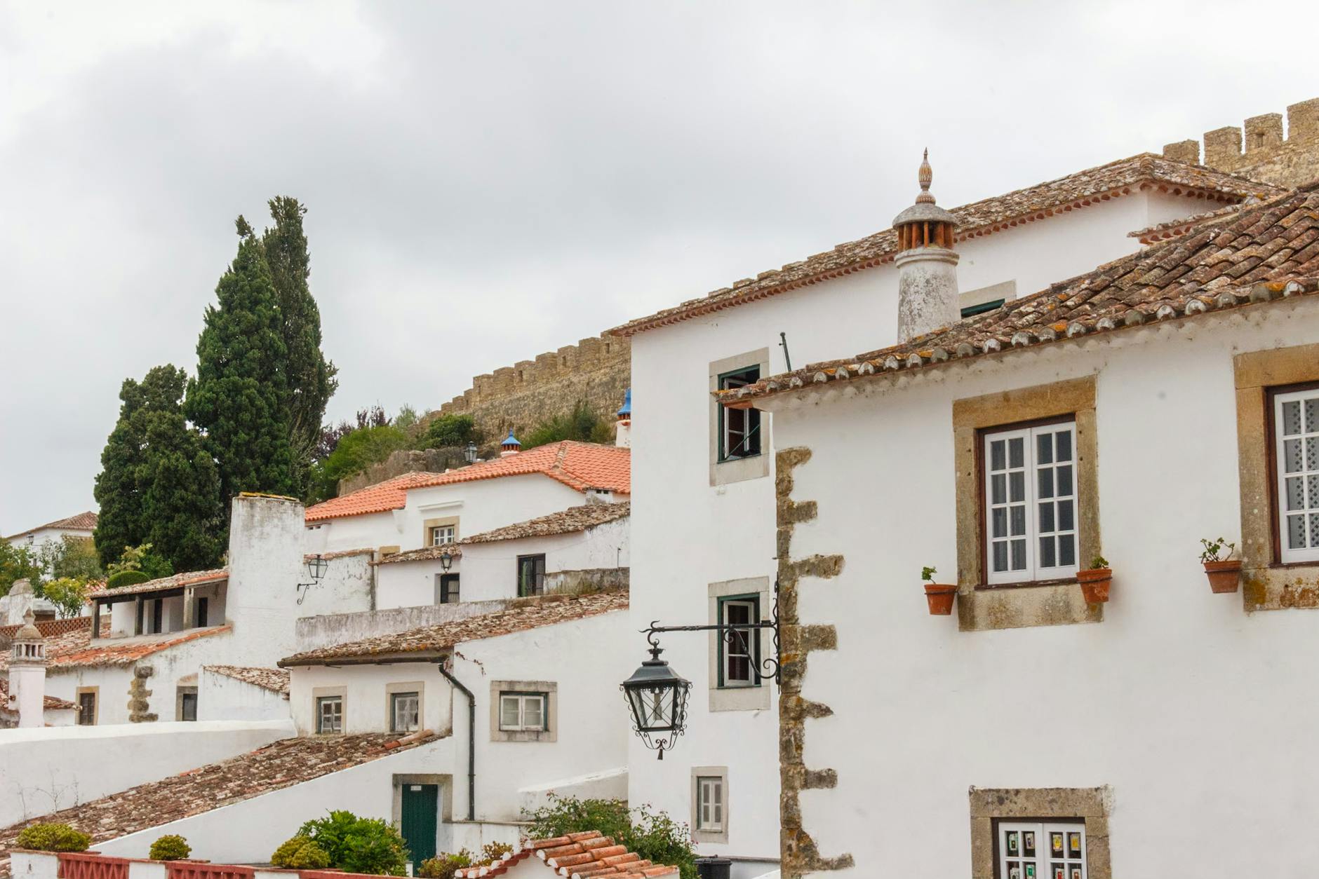 Medieval walled town of Óbidos Portugal with whitewashed houses and flowers