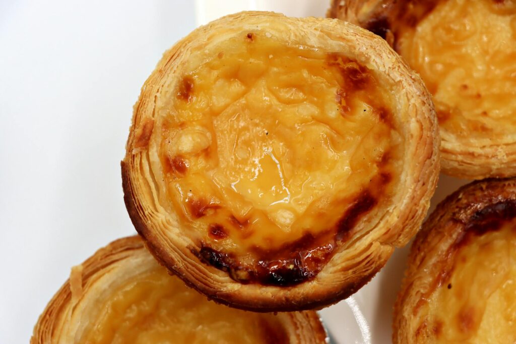 Traditional Portuguese pastel de nata custard tarts with flaky pastry and caramelized custard filling