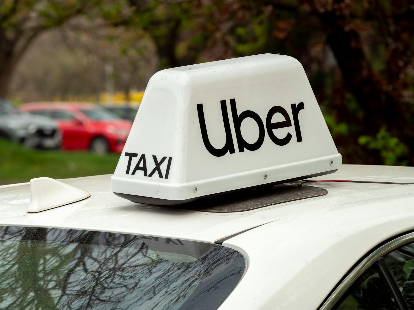 Uber driver at Lisbon airport pickup zone with luggage and modern car