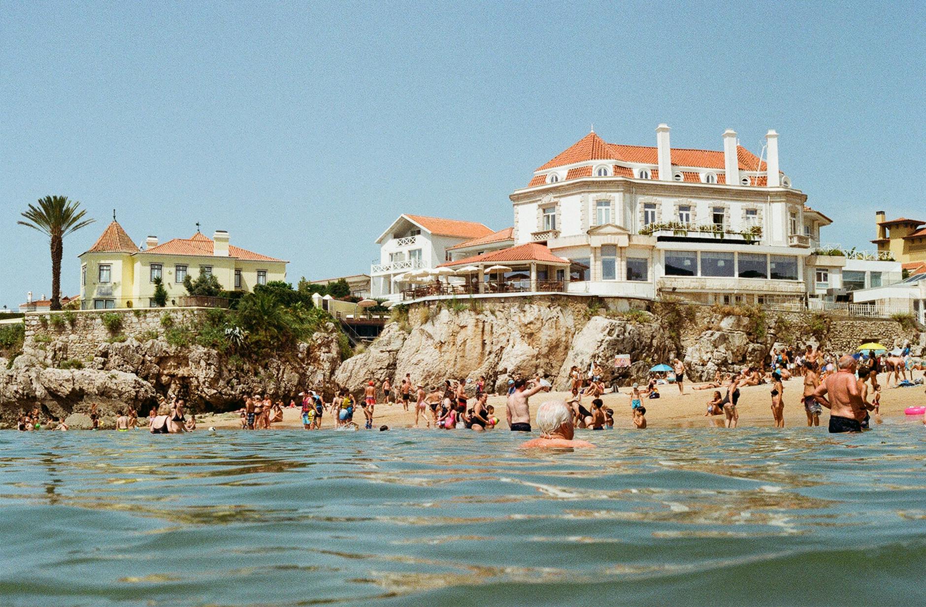 Busy beach at Cascais Portugal with sunbathers by the Atlantic oceanfront resort