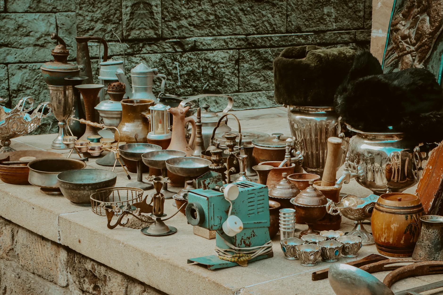 Vintage kitchenware and decorative items on a Feira da Ladra market stall in Lisbon