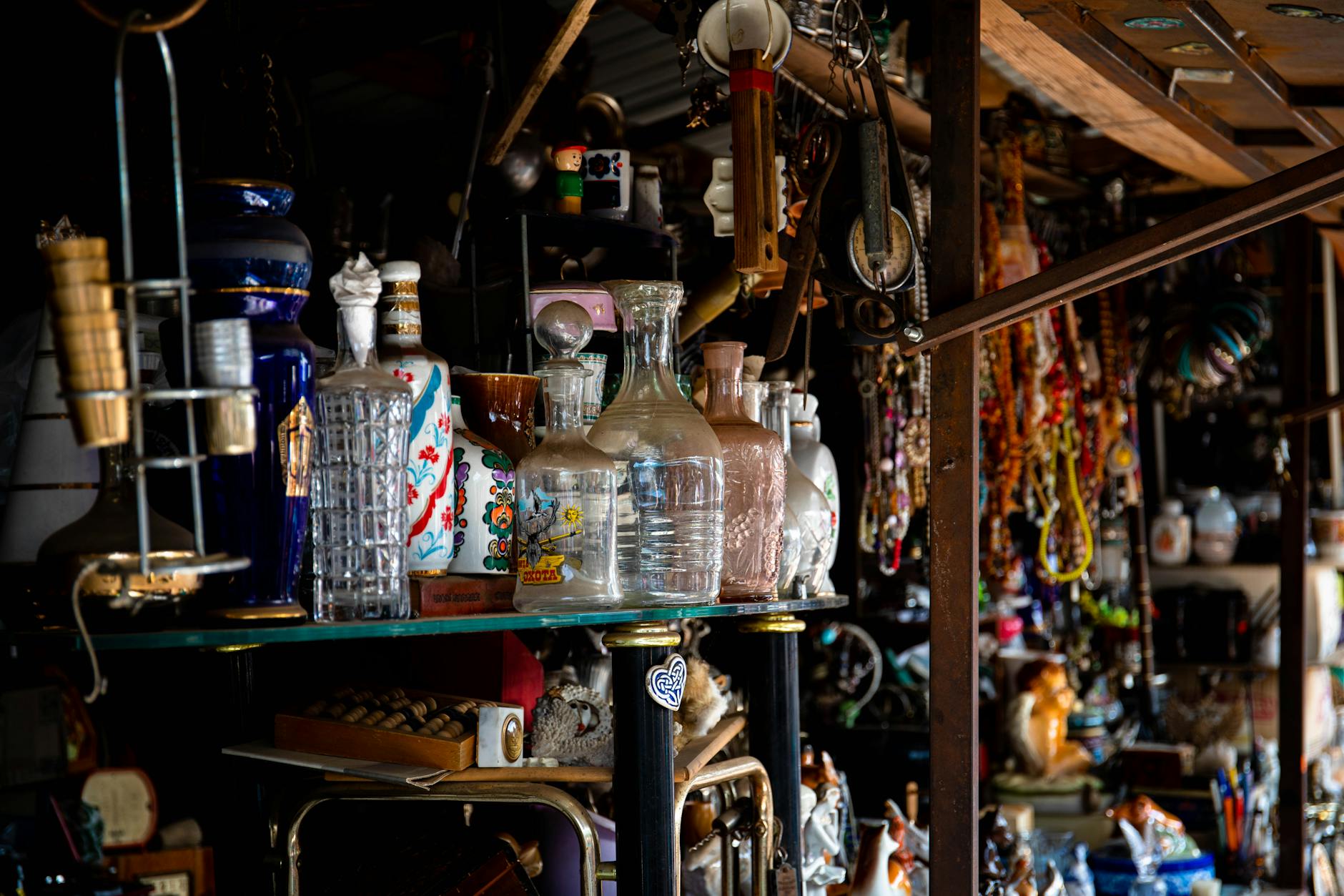 Assortment of vintage glassware and decorative items on an antique market stall