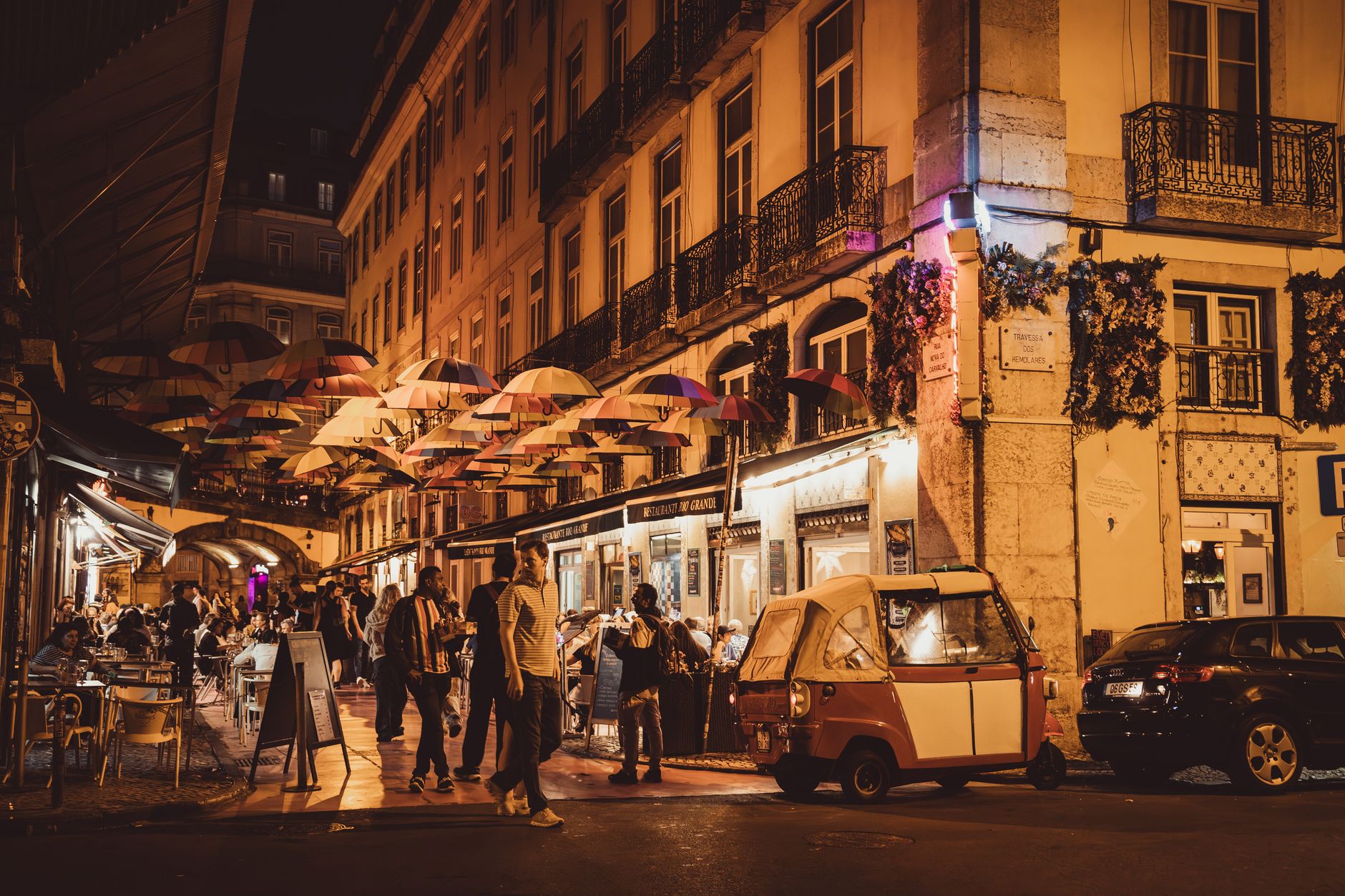 Cais do Sodré street at night with bars, umbrellas and crowds — Lisbon nightlife