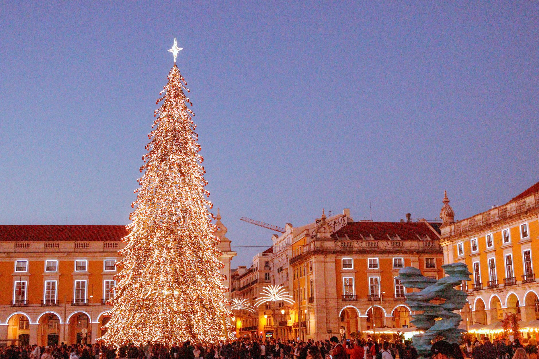 Festive Christmas tree illuminated at Praça do Comércio Lisbon during winter evening