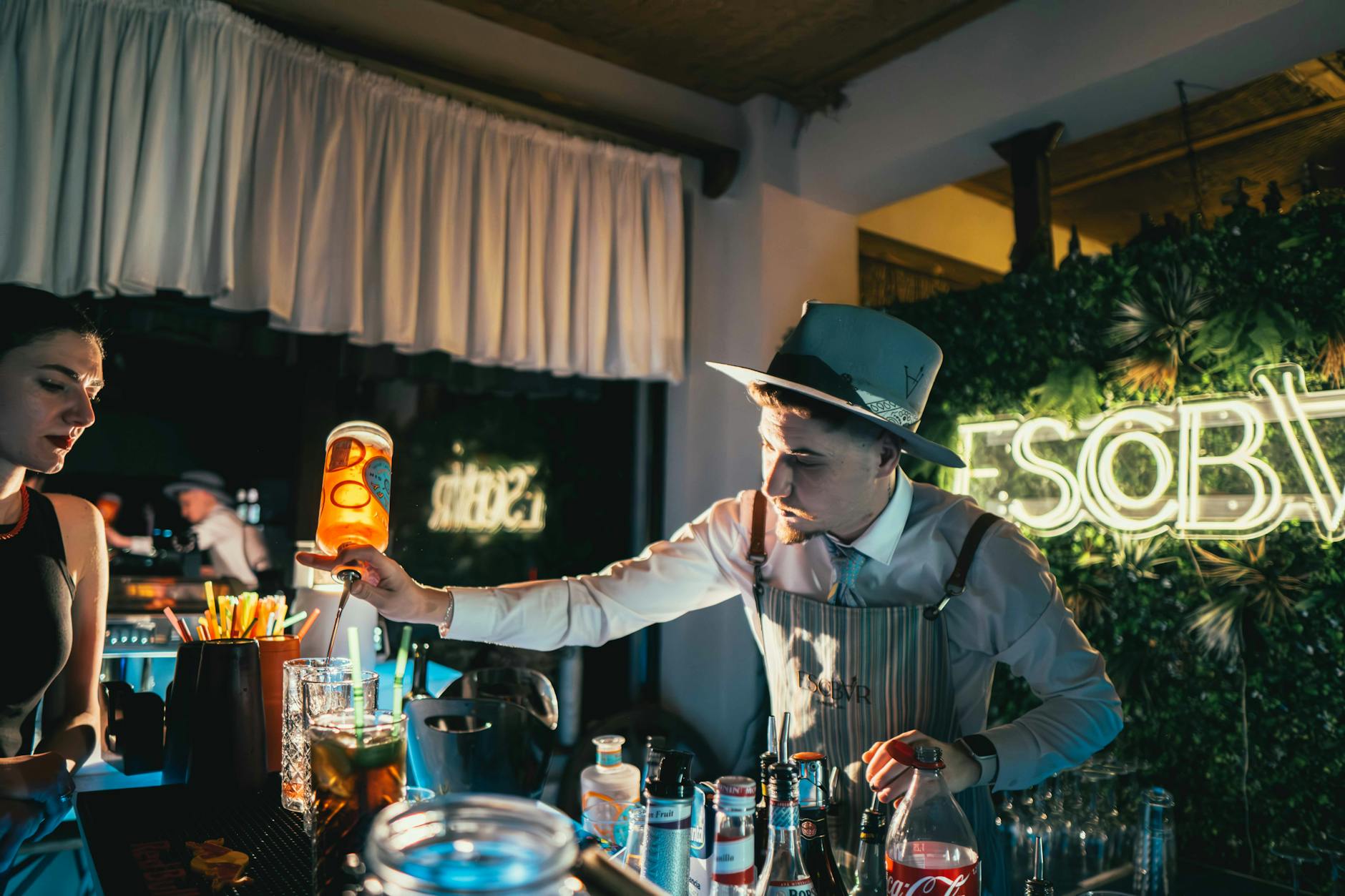 Bartender mixing cocktails at a Lisbon bar at night