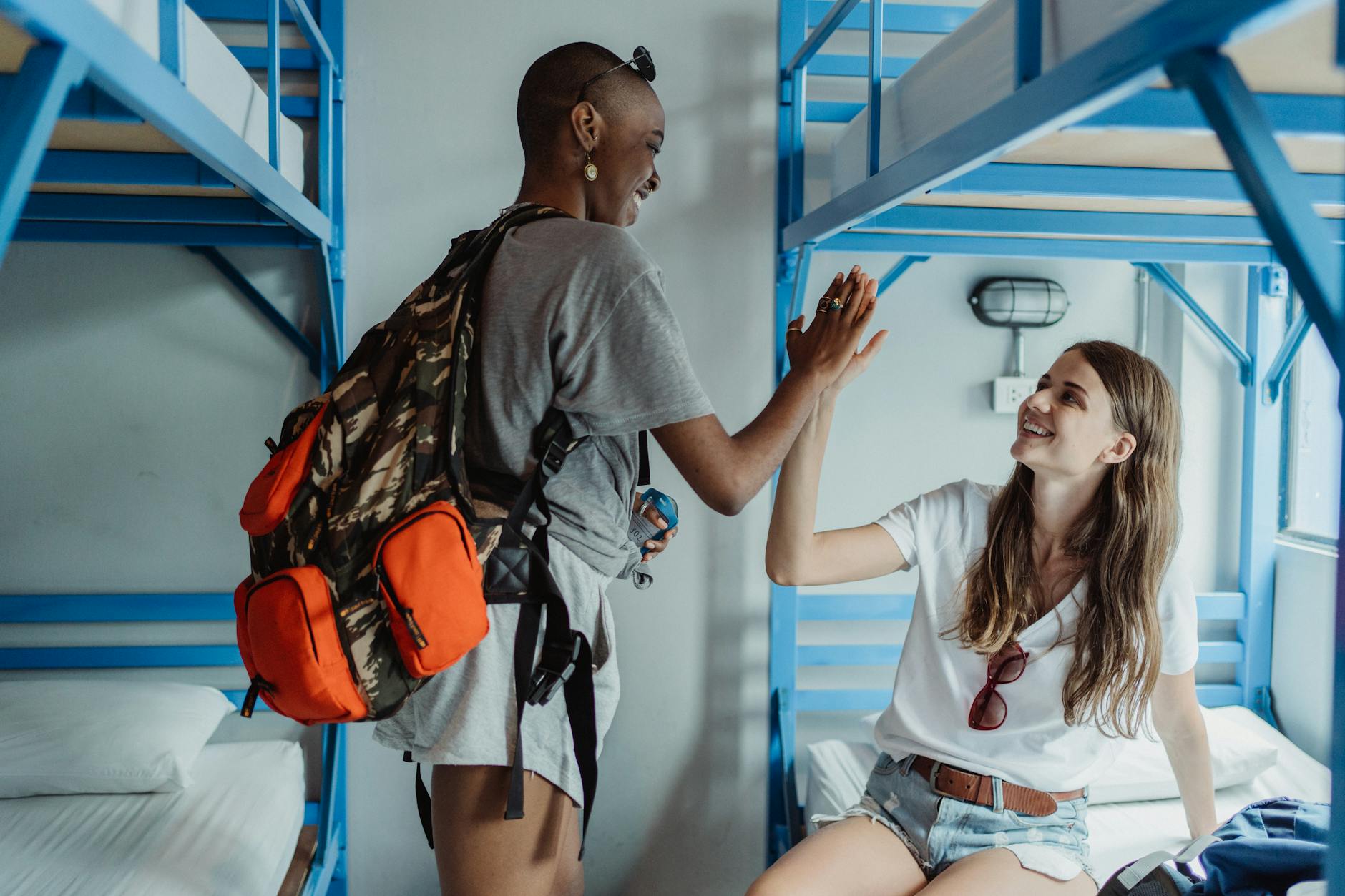 Backpackers in a hostel dorm room in Lisbon celebrating their travels