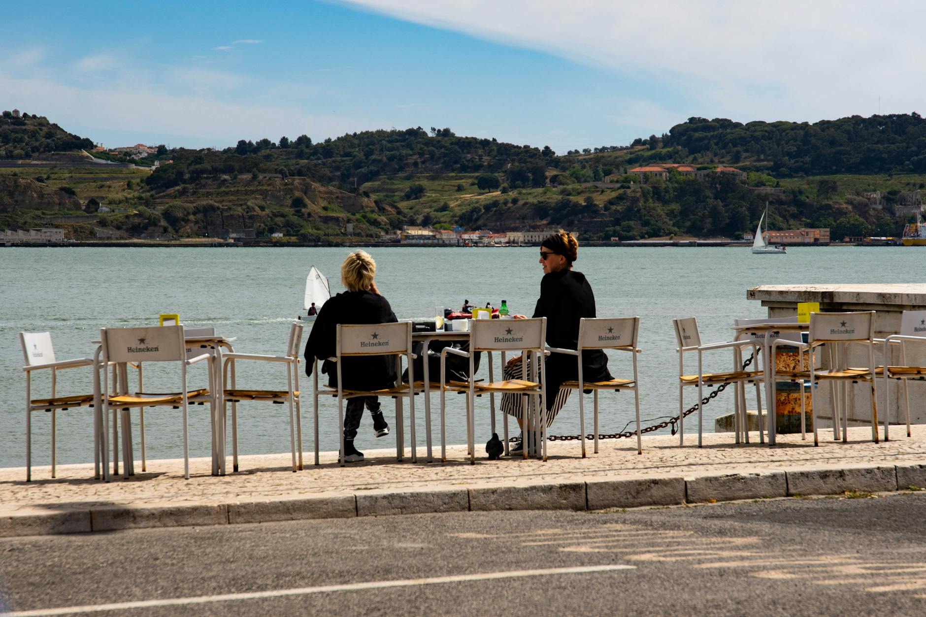 Outdoor restaurant dining in Lisbon overlooking the waterfront and hills