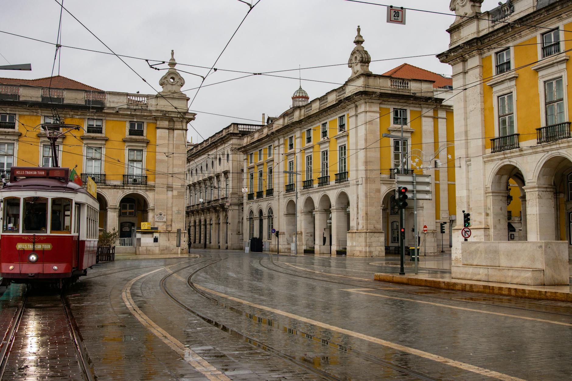 Lisbon tram at Praca do Comercio on a rainy day with wet cobblestones