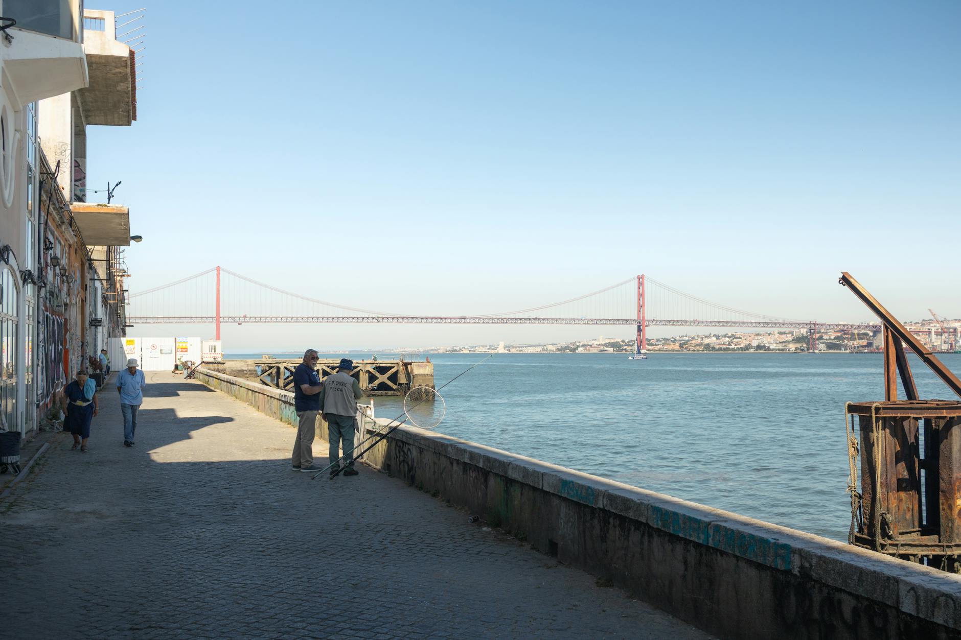 The 25 de Abril Bridge seen along the Ginjal waterfront at Cacilhas, across the Tagus from Lisbon