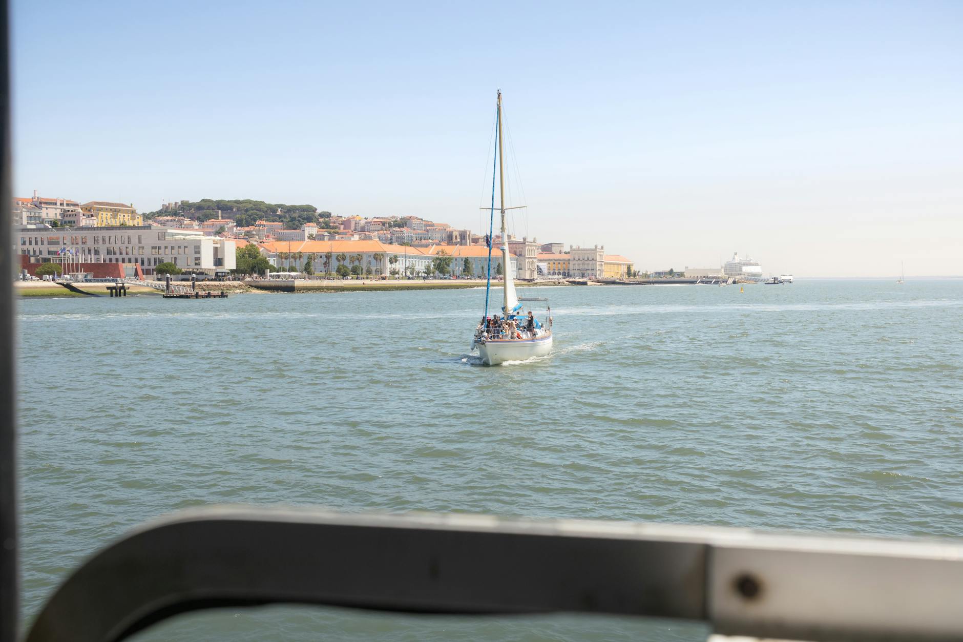 Sailboat with tourists on the Tagus River with Lisbon waterfront behind