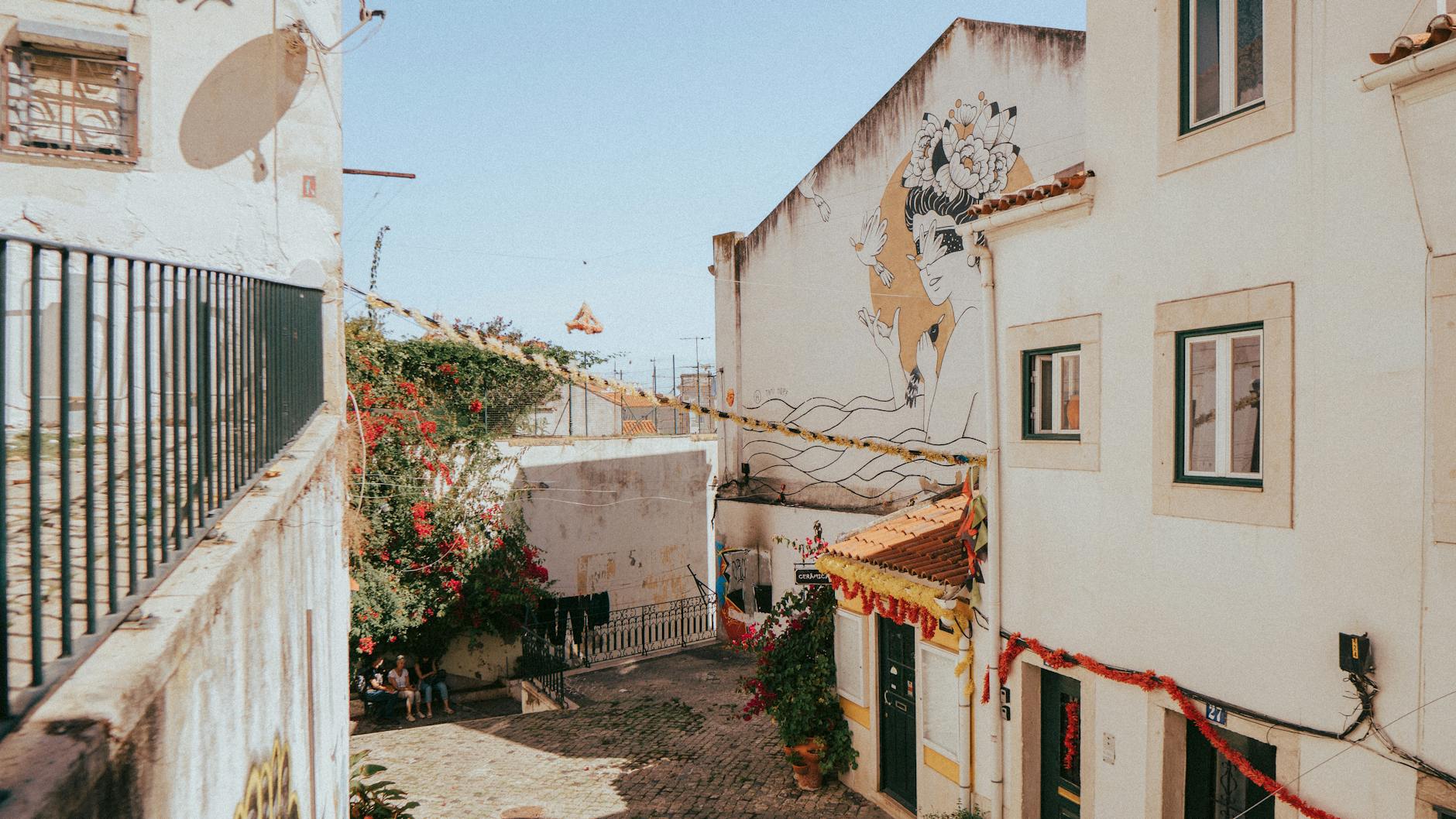 Colourful alley in Lisbon Portugal with mural art and festive decorations