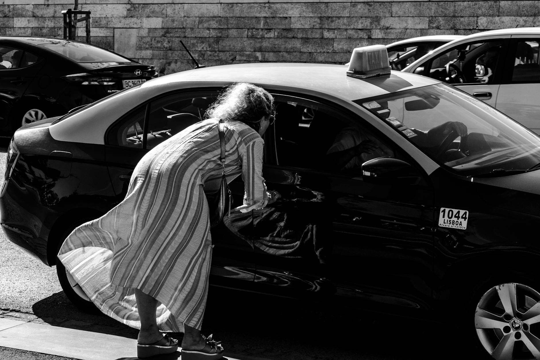 Woman hailing a taxi on a busy Lisbon street
