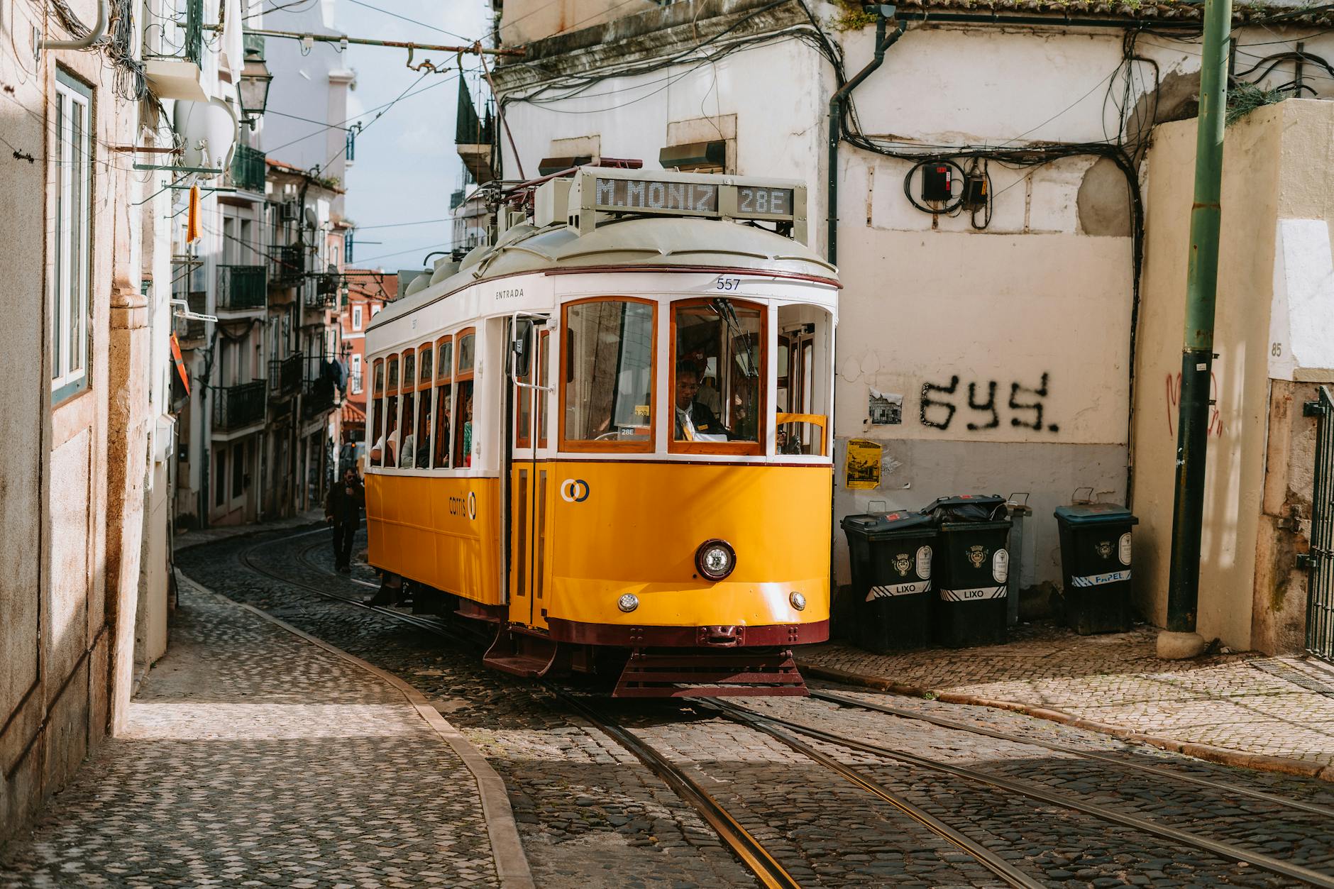 Yellow Tram 28 on cobblestone street in Alfama Lisbon walking route