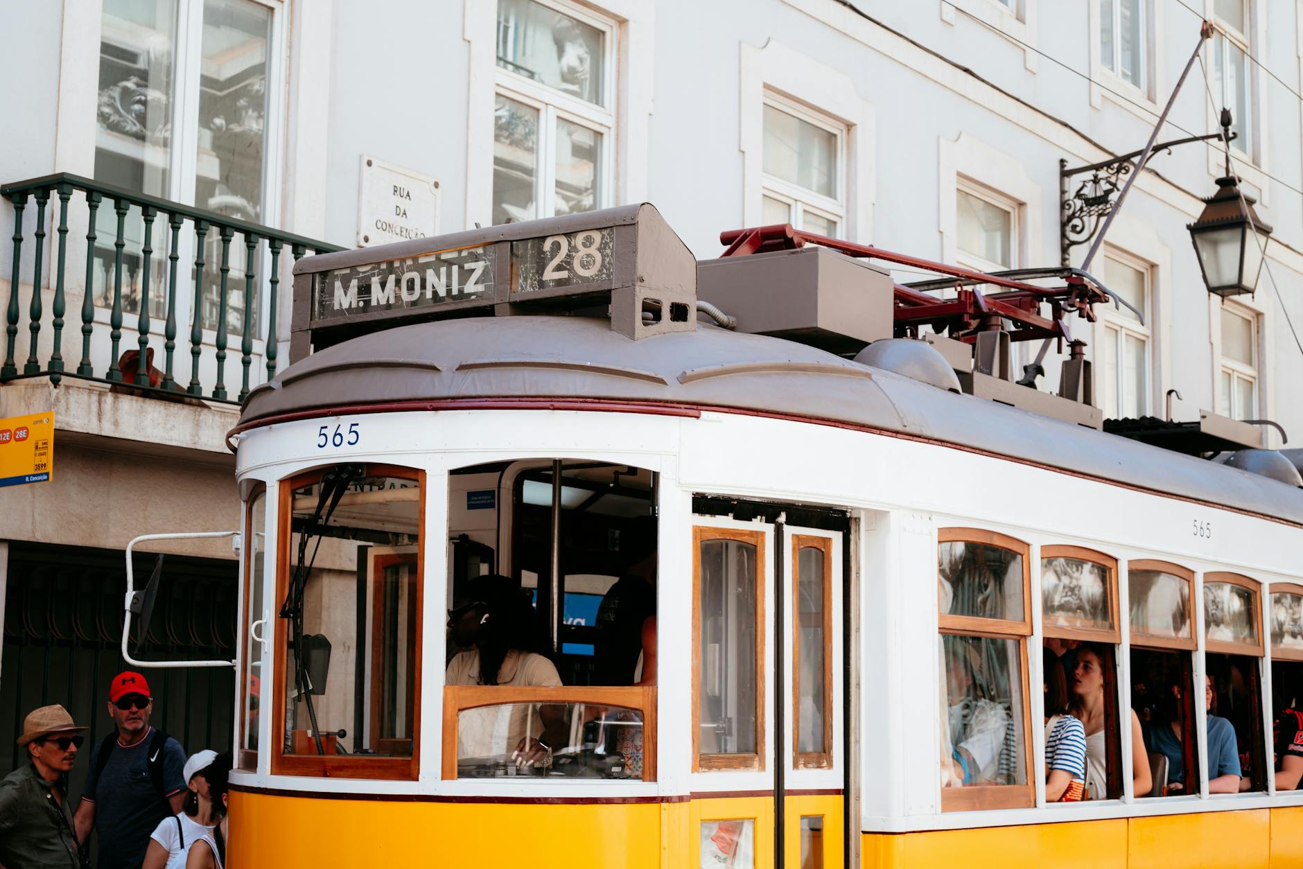 Passengers riding a vintage Lisbon tram through the city