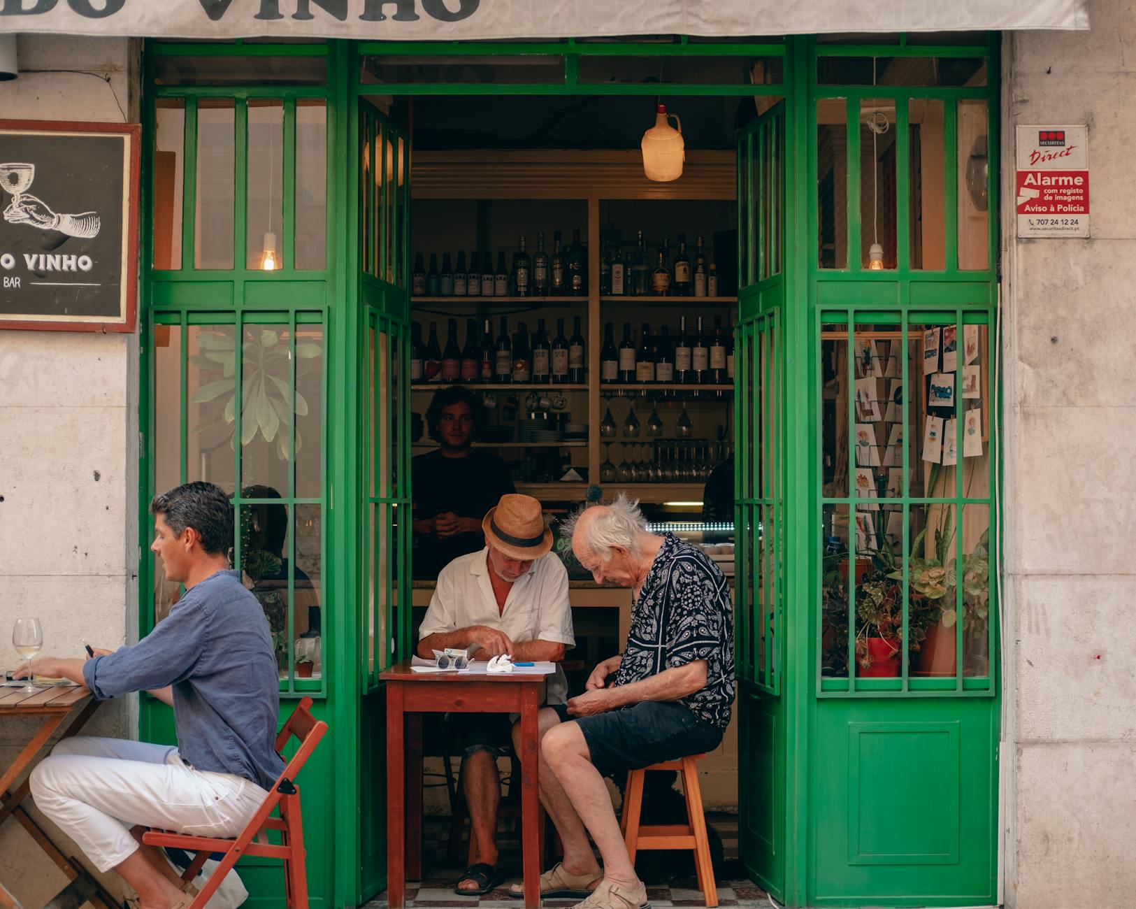 Men enjoying drinks at a Lisbon wine bar on a street in Portugal