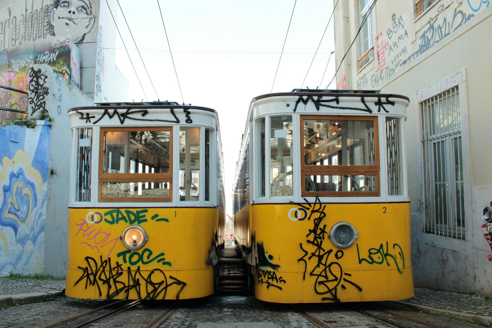 Yellow trams on graffiti-covered street in Lisbon Portugal solo travel