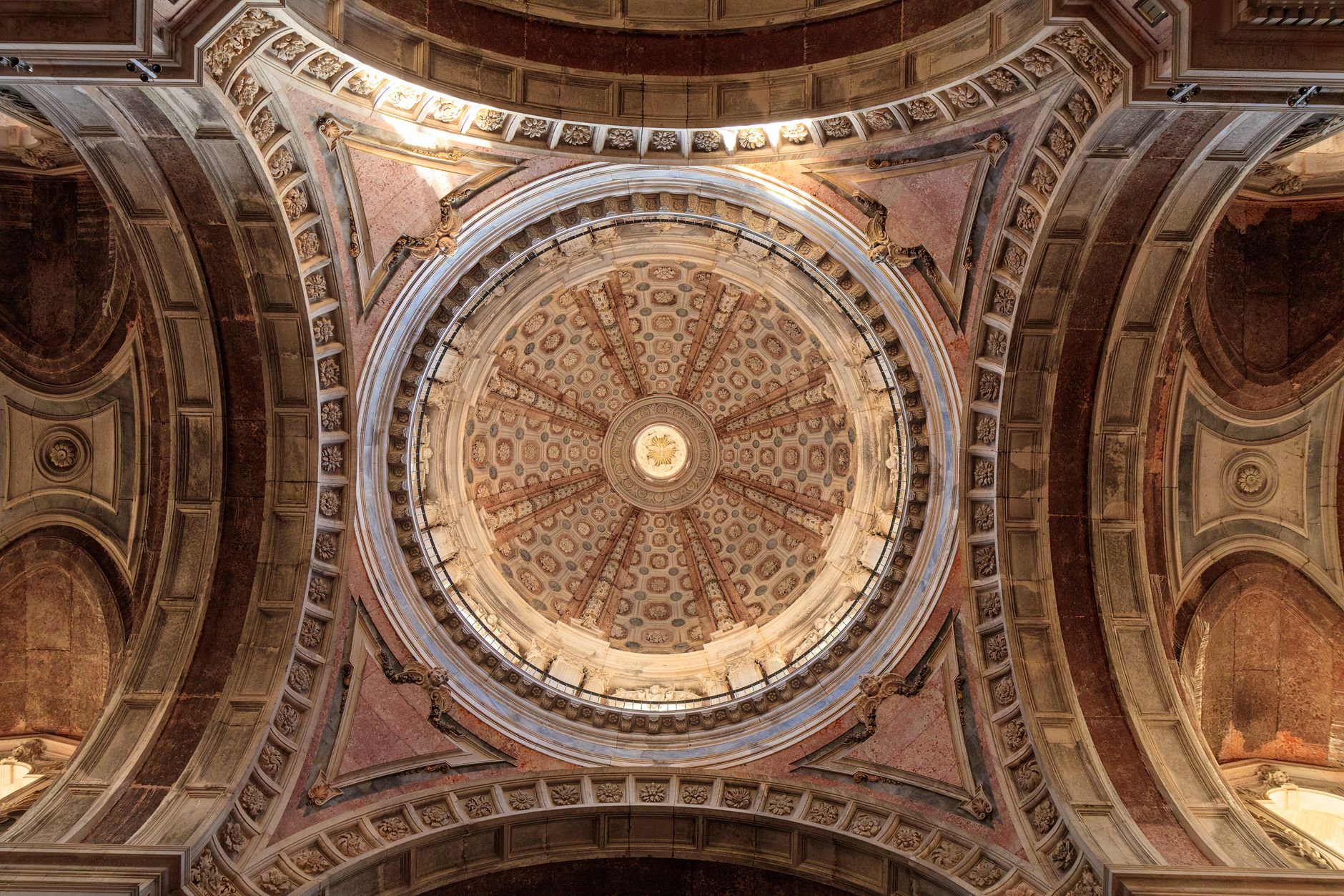 Baroque dome interior of Mafra National Palace basilica with ornate stone carvings
