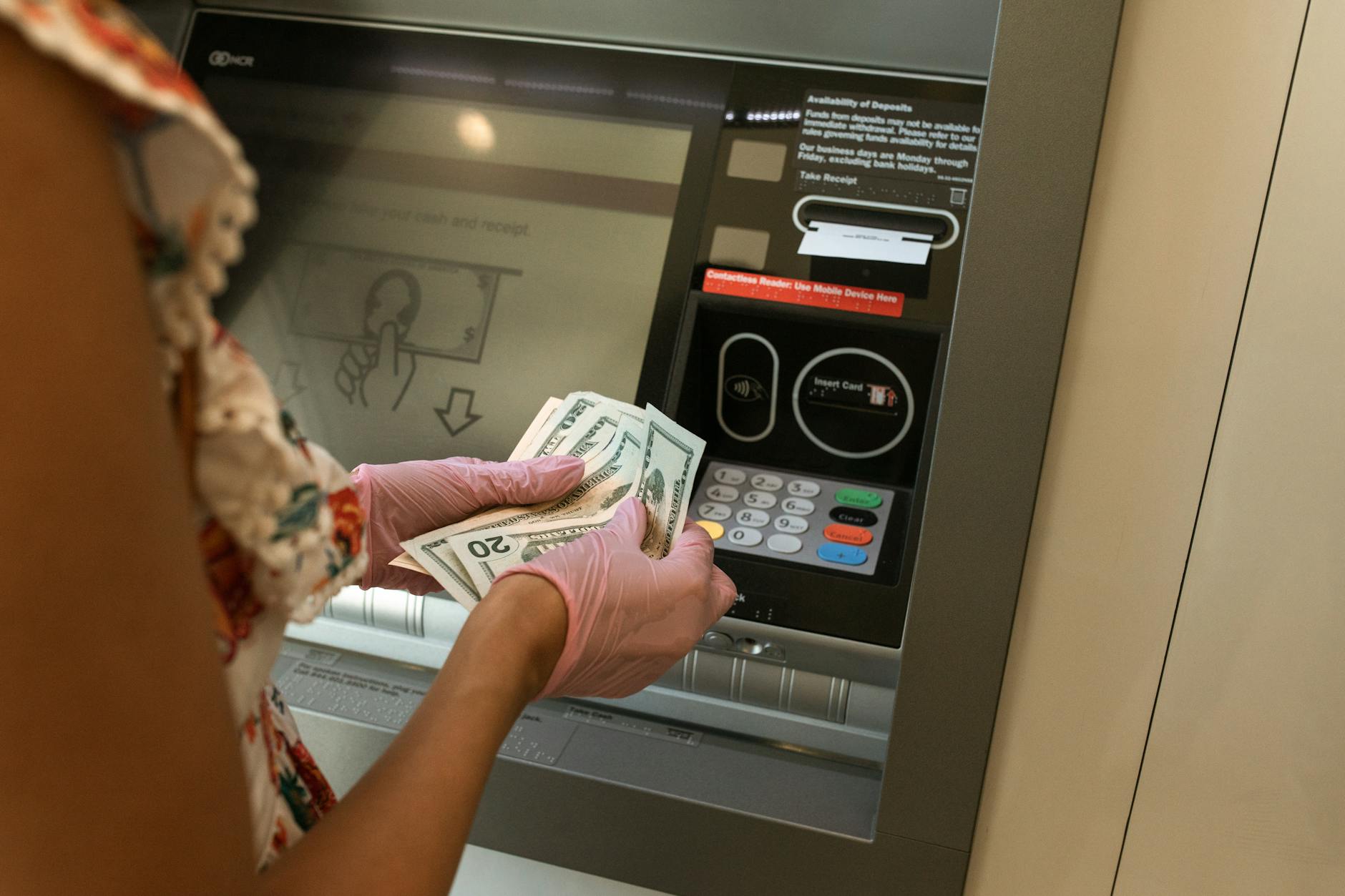 Person withdrawing cash from a Multibanco ATM in Lisbon