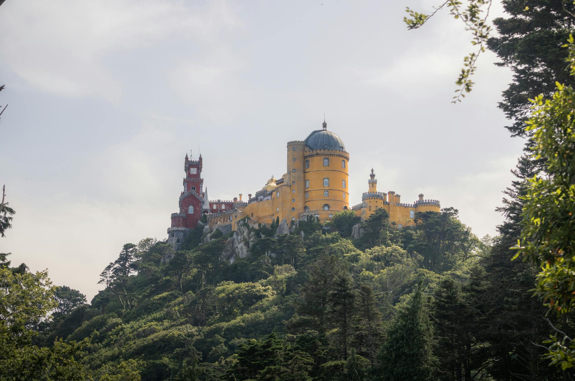 Pena Palace Sintra hilltop with colorful facade surrounded by green forest