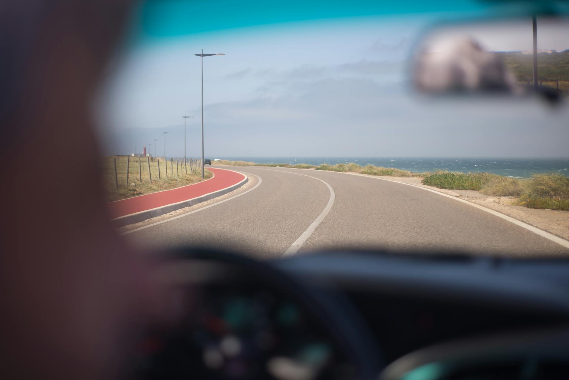 Scenic drive along Portuguese coastline through windshield sunny day