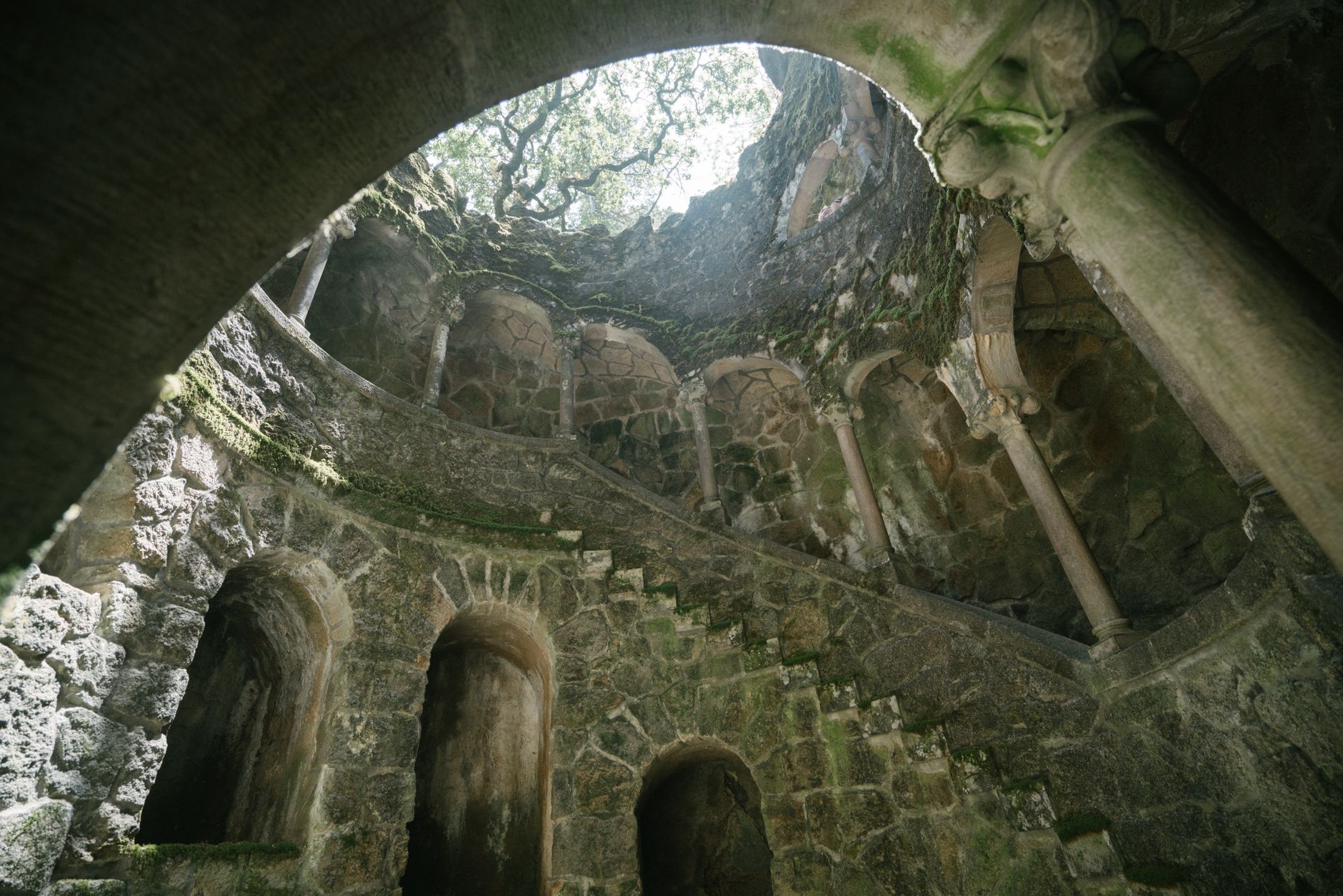 Spiral staircase descending into Quinta da Regaleira Initiation Well, Sintra Portugal