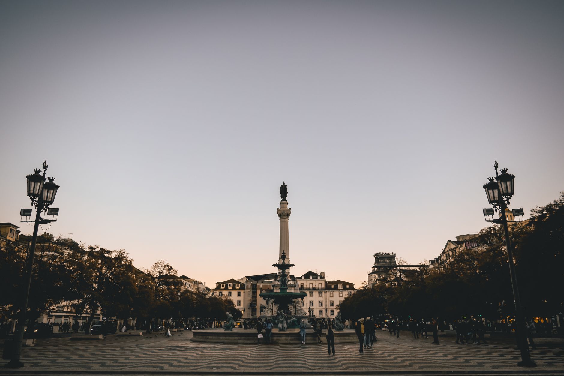 Rossio Square in Lisbon at twilight with lights and historic architecture