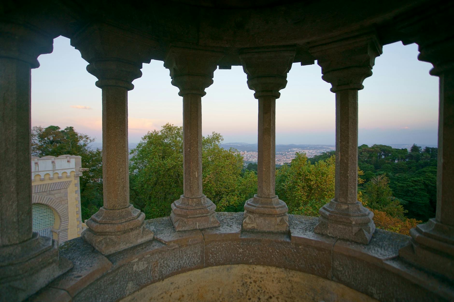 Gothic columns framing Sintra landscape view from palace grounds