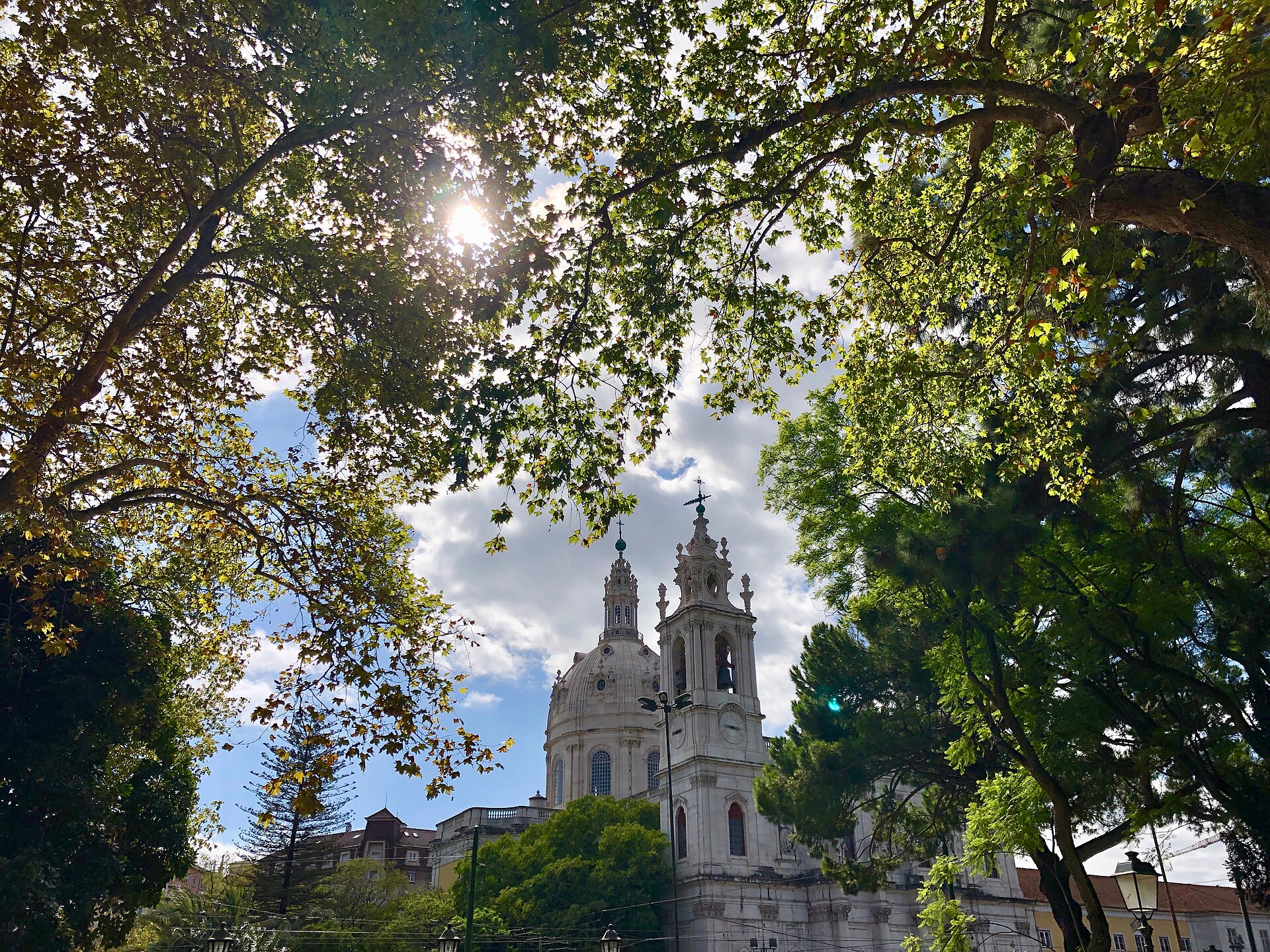 The dome and bell tower of the Basílica da Estrela seen through the trees of the Jardim da Estrela in Lisbon