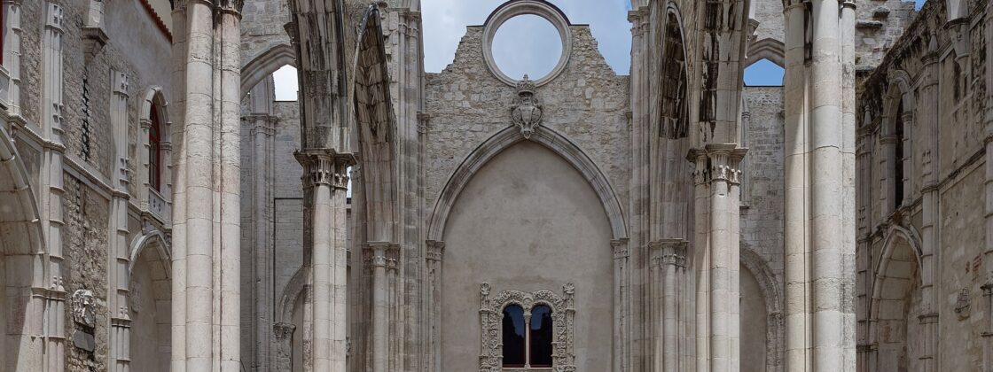 Roofless Gothic nave of the Carmo Convent in Lisbon with pointed arches open to the sky