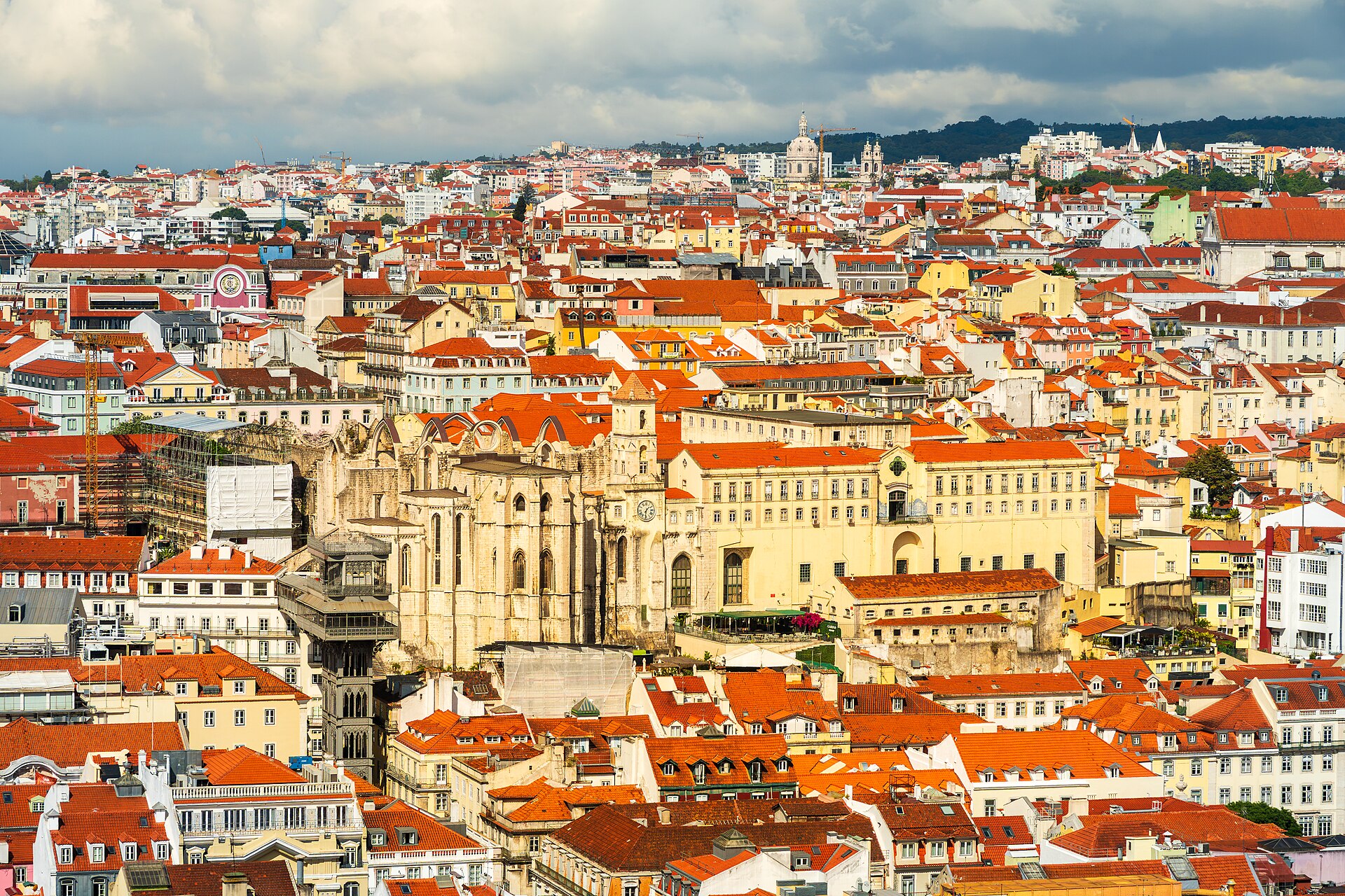 Aerial view over Lisbon rooftops showing the roofless Carmo Convent and the Santa Justa Elevator