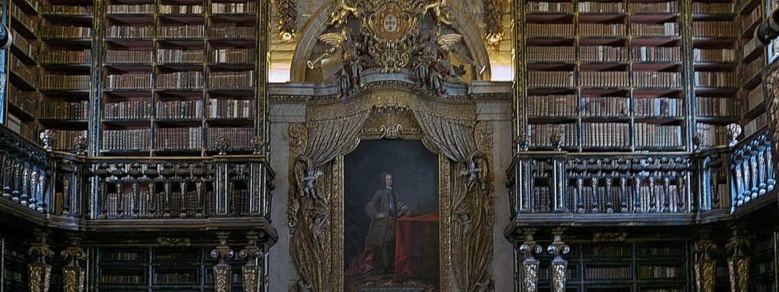 The gilded baroque interior of the Biblioteca Joanina at the University of Coimbra with tiered bookshelves