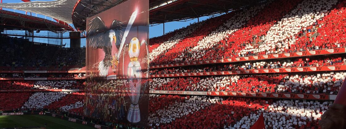 Packed red and white stands at the Estadio da Luz with a giant eagle tifo banner before a Benfica match