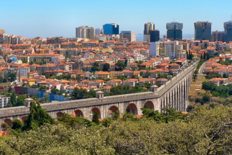 Arches of the Aqueduto das Águas Livres crossing the Alcântara valley in Lisbon with the city behind