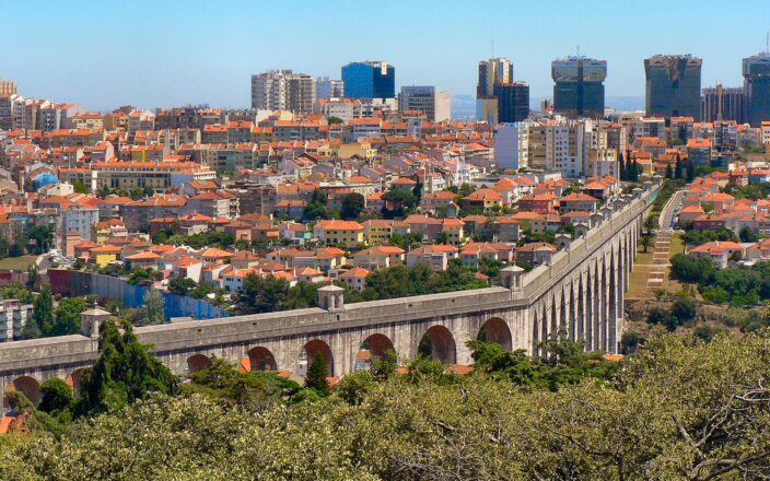 Arches of the Aqueduto das Águas Livres crossing the Alcântara valley in Lisbon with the city behind