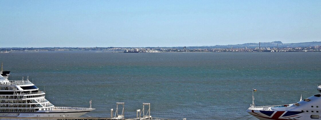 Cruise ships alongside the white Lisbon Cruise Terminal building at Jardim do Tabaco on the Tagus