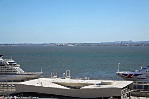 Cruise ships alongside the white Lisbon Cruise Terminal building at Jardim do Tabaco on the Tagus
