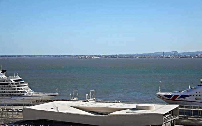 Cruise ships alongside the white Lisbon Cruise Terminal building at Jardim do Tabaco on the Tagus