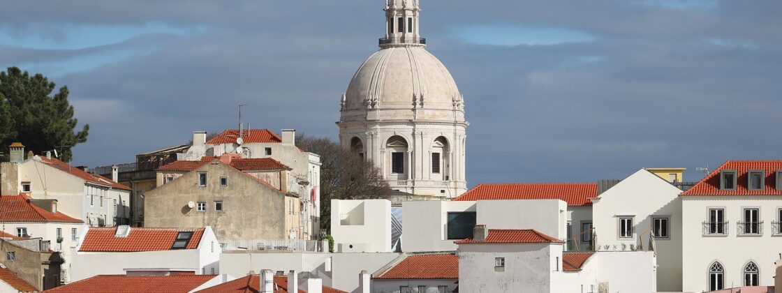 White dome of the Panteao Nacional rising above the red rooftops of Alfama in Lisbon