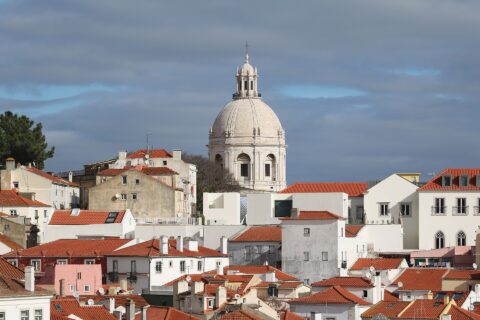 White dome of the Panteao Nacional rising above the red rooftops of Alfama in Lisbon