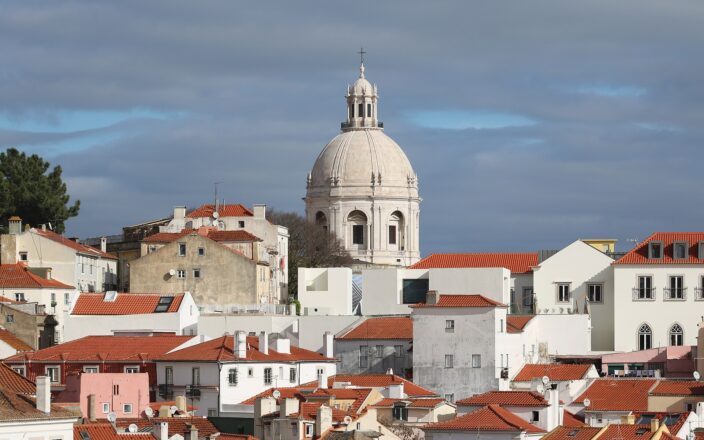 White dome of the Panteao Nacional rising above the red rooftops of Alfama in Lisbon