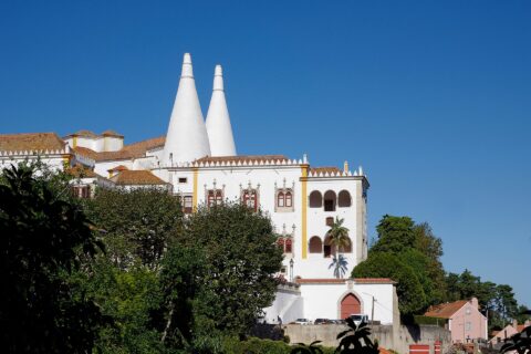 The National Palace of Sintra with its two enormous white conical kitchen chimneys rising above the town rooftops