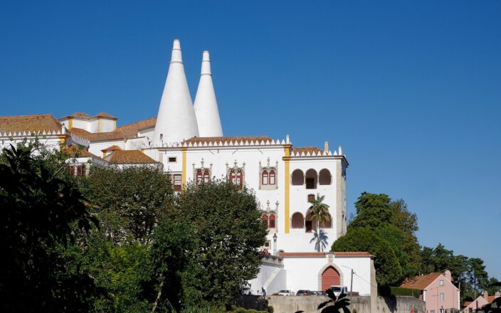 The National Palace of Sintra with its two enormous white conical kitchen chimneys rising above the town rooftops