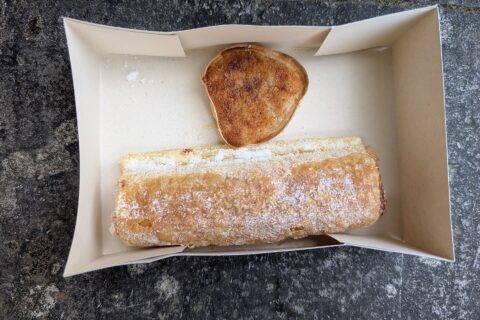 A sugar-dusted travesseiro and a queijada de Sintra in a paper pastry box